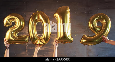 Nouvelle année 2017 est à venir ! Les ballons d'or avec des numéros dans les mains sur fond sombre Banque D'Images
