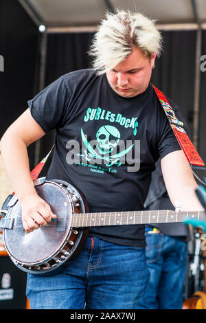 Groupe de rock français, sur les docks sur scène lors de Faversham Hop Festival. Portrait d'un membre du groupe jouant le banjo. Banque D'Images