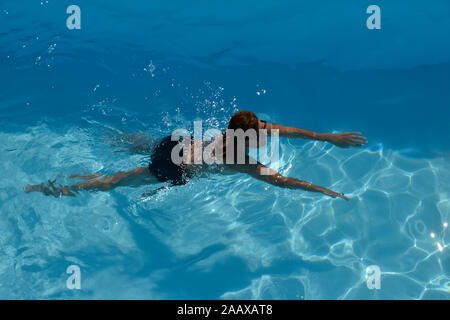 Un portrait d'une femme nager dans l'eau bleu clair. Banque D'Images