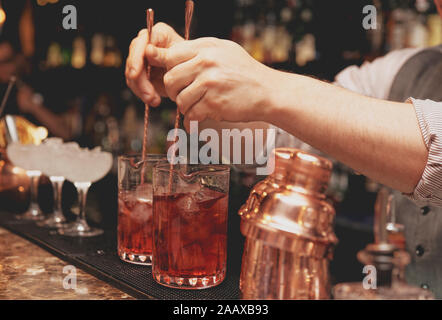 Barman est en remuant des cocktails sur comptoir bar Banque D'Images