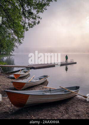 Beauté tranquille matin avec chaloupe et jetée à l'aube d'été misty dans la plage idyllique de la Finlande Banque D'Images