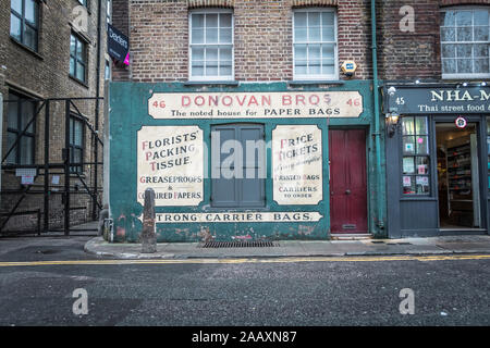 Donovan Bros avec un sac en papier boutique sur Crispin Street, Spitalfields, Londres E1, UK Banque D'Images