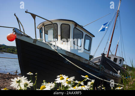 Une flotte de vieux, en bois, bateaux de pêche amarrés sur un quai le long de la baie de Broadford à Broadford, Ile de Skye, Ecosse, Royaume-Uni. Banque D'Images