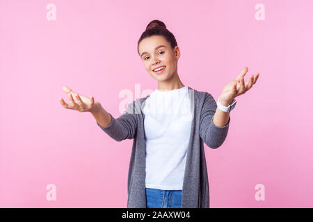 Portrait de genre bon caractère brunette woman bun hairstyle dans les tenues de raising arms dans geste me donner hug, à moyens hospitaliers Banque D'Images