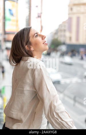 Smiling woman leaning on railing balcon Banque D'Images