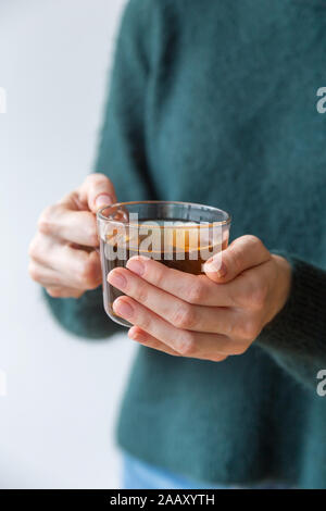 Plateau en verre tasse in women's hands avec pas de manucure. Concept de la photo pour l'humeur d'hiver douillet Banque D'Images