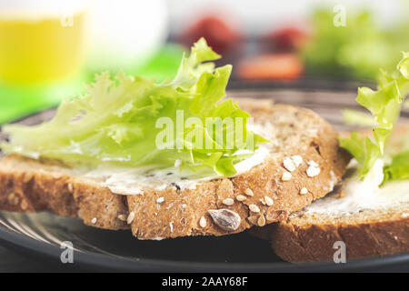 Sandwich avec de la laitue verte sur du pain aux céréales. Banque D'Images