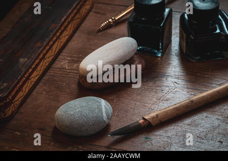 Stylos de calligraphie et l'encre sur la vieille table en bois. week-end hobby décoration ,avec bambou. & plumes Banque D'Images