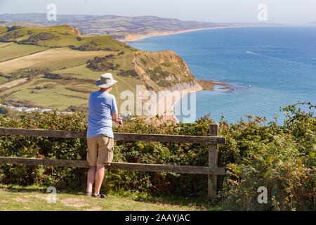 Personne prend dans la vue sur la mer depuis le haut de Golden Cap Ouest dans le Dorset, en Angleterre, avec vue sur l'arrière-plan des falaises de grès et de Bridport b Chesil Banque D'Images