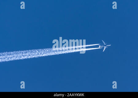 Les avions laissant traînée trace sur un ciel bleu clair Banque D'Images