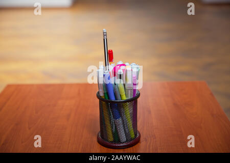 Boîte pour stylos et crayons . Crayons de couleur dans une trousse sur la table en bois . Crayons de couleur en noir cas . Close-Up crayons de couleur et des marqueurs dans Banque D'Images