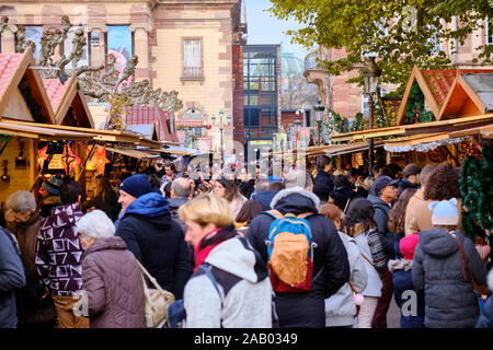 Foule de gens marcher entre tous les aliments et des marchands de souvenirs au milieu de la ville au marché de Noël de Strasbourg Banque D'Images