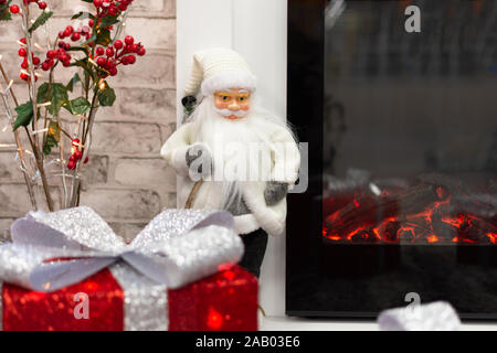 Nouvelle Année maison décorée avec des boîtes-cadeaux, l'emballage rouge Santa présente et décorations de Noël. Salle de séjour avec cheminée décorée pour Noël hol Banque D'Images