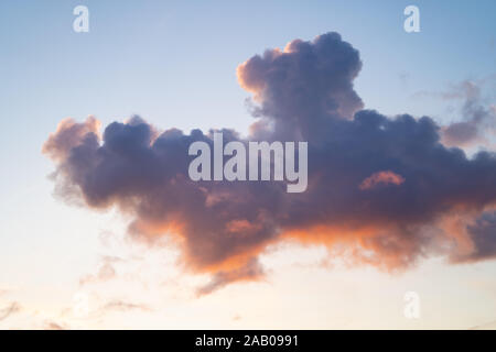 Maquereaux ciel. Ciel bleu avec nuages fragmentés de lumière avec le soleil donnant une douce couleur rose / orange Banque D'Images