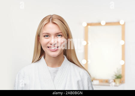 Jolie jeune femme blonde avec dents sourire debout devant la caméra de Banque D'Images