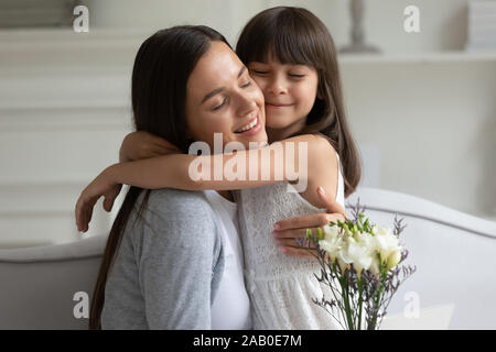 Mère fille caresser la remercie pour les fleurs à l'anniversaire Banque D'Images