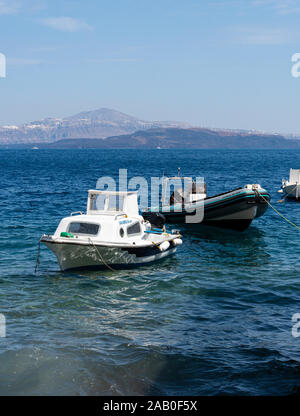 Ormos Korfou, Grèce - 16 juillet 2019 : deux bateaux, un canot et une petite cabine cruiser, attachés dans les eaux de la mer Égée au quai de Ormos Ko Banque D'Images