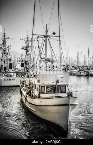 Un bateau de pêche commercial lance des quais de la marina dans le port de Santa Barbara, en Californie du Sud, noir et blanc Banque D'Images