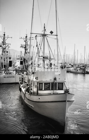 Un bateau de pêche commercial lance des quais de la marina dans le port de Santa Barbara, en Californie du Sud, noir et blanc Banque D'Images