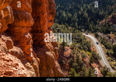 Depuis les tours de red rock canyon étroit à route avec deux camions de prendre la route jusqu'à la petit canyon dans l'Utah du sud sauvage. Banque D'Images