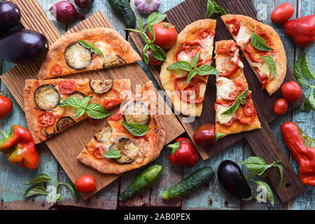 Repas végétarien sain. Des pizzas rustiques avec des légumes sur les planches à découper en chêne avec des ingrédients crus vue ci-dessus Banque D'Images