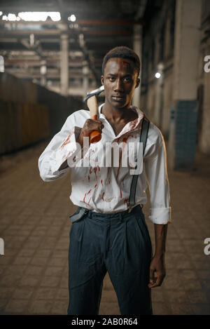Homme avec ax en usine abandonnée, zombie land Banque D'Images