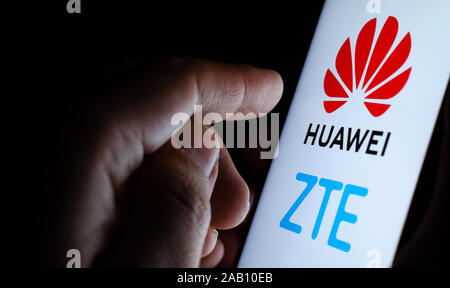 Huawei et ZTE logos sur un smartphone et un utilisateur de toucher l'écran. Photo pour le concept l'actualité des fournisseurs chinois de 5G le matériel de télécommunications. Banque D'Images