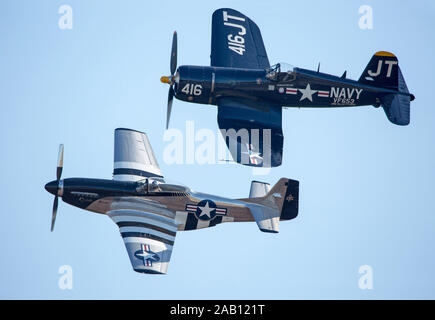 MONROE, NC (USA) - 9 novembre 2019 : P-51 Mustang et Vought F4U Corsair fighter les avions volent en formation rapprochée au cours d'un salon. Banque D'Images