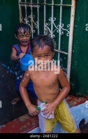 Un enfant joue avec l'eau pendant le festival de Higantes à Angono Philippines Banque D'Images