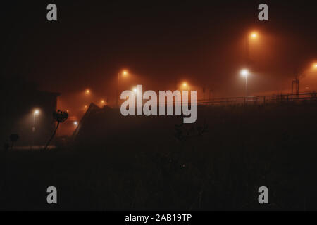 Lumière dramatique sur un pont pendant une nuit brumeuse à Leipzig, Allemagne Banque D'Images