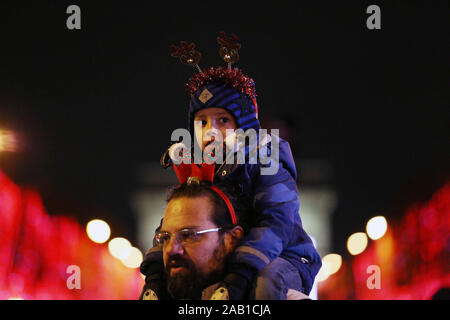 Paris, l'Avenue des Champs-Élysées annuel Noël illuminations cas a débuté à Paris le dimanche. 8 janvier, 2020. Un homme et son enfant assister à l'inauguration de l'Avenue des Champs-Élysées Noël illuminations de Paris, France, 24 novembre 2019. L'assemblée annuelle de l'événement Noël illuminations de l'Avenue des Champs-Elysées a débuté à Paris le dimanche, qui durera jusqu'au 8 janvier 2020. Credit : Gao Jing/Xinhua/Alamy Live News Banque D'Images