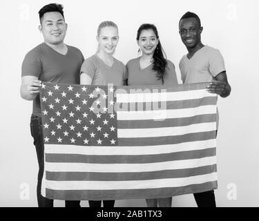 Studio shot of happy groupe diversifié de multi ethnic friends smiling en maintenant le drapeau Américain ensemble Banque D'Images