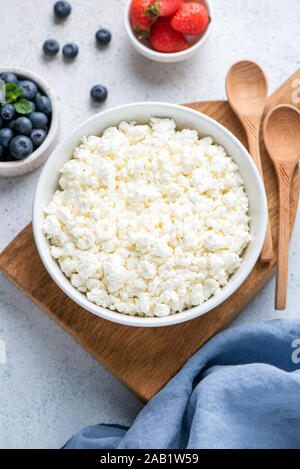 Fromage blanc, le fromage cottage ou ricotta Tvorog, servi dans un bol avec les baies fraîches. Vue de dessus de table. Produits laitiers fermentés riches en protéines, gras sain Banque D'Images