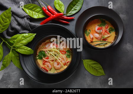 Soupe de Laksa – soupe de curry de noix de coco malaisienne aux crevettes sur des nouilles de riz, surmontée d'épi de haricots frais, de concombre, de lime, de coriandre au piment rouge Banque D'Images