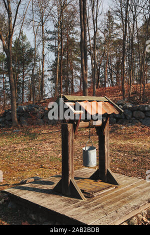 Puits de tirage traditionnel en bois avec seau en métal, île de Fjaderholmarna, archipel de Stockholm, Suède Banque D'Images