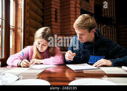 L'homme et la femme signer des documents à une table dans un cafe Banque D'Images