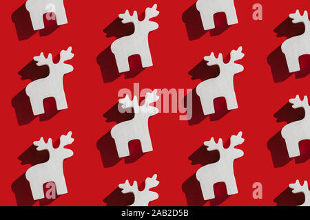 Motif de décoration de Noël en bois blanc deer sur fond rouge. Concept de Noël. Banque D'Images