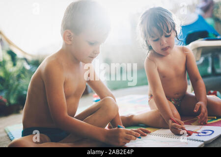 Petit garçon et fille dessin avec des crayons de couleur Banque D'Images
