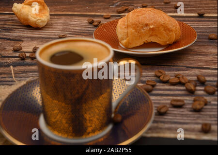 Tasse de café, croissants et les grains de café sur fond de bois. Close up Banque D'Images