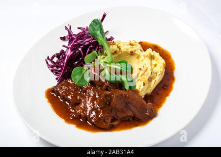 Dans les joues de veau sauce avec des pommes de terre et le chou, d'herbes décoré Banque D'Images