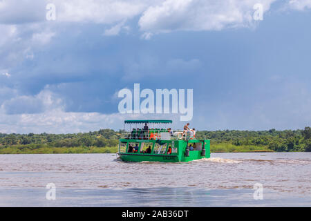 Safari de faune touristique typique en cours bateau naviguant sur le Nil Victoria, au nord ouest de l'Ouganda sur une journée ensoleillée avec des nuages de pluie Banque D'Images