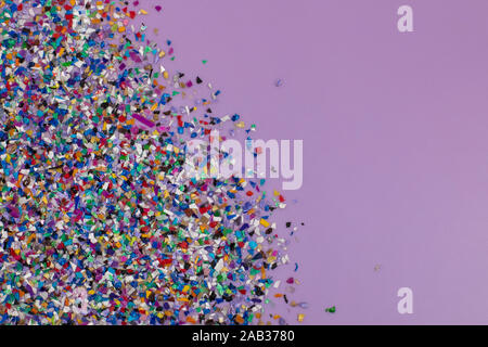 Les granules de plastique recyclé provenant de l'eau de mer, un flatlay sur fond violet lilas. Pièces colorées. Repenser l'environnement en réduisant Banque D'Images