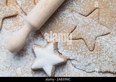 Cookies stars coupé de la préparation de la pâte avant cuisson avec prêt de la biscuiterie et Rolling pin Banque D'Images