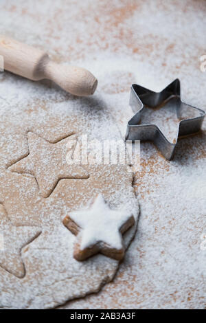 Cookies stars coupé de la préparation de la pâte avant cuisson avec des biscuits préparés, rouleau à pâtisserie et la faucheuse. Banque D'Images