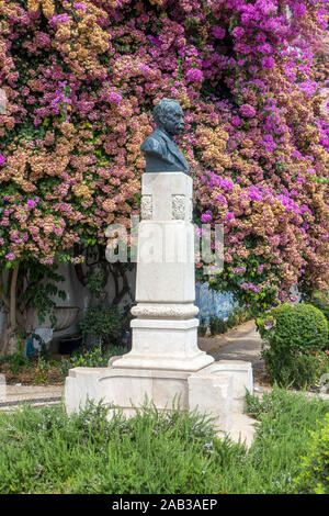 Buste de l'historien portugais Julio de Castilho dans le Miradouro de Santa Luzia, Alfama, Lisbonne sur un fond de fleurs de bougainvilliers Banque D'Images