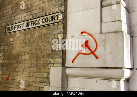 Bombe de peinture Graffiti rouge symbole communiste de la faucille, marteau et, sur le mur d'une banque - Norwich, UK Banque D'Images