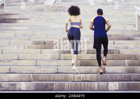 Les jeunes coureurs couple running à l'étage sur l'escalier de la ville, forme physique, entraînement sportif urbain et mode de vie sain concept, copie espace pour le texte Banque D'Images