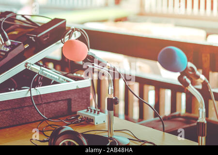 Deux microphones avec éponges rouges et bleus sur un support placé avec écouteurs sur la table avec l'image du barbouillage du technicien audio a été l'installation et le sev Banque D'Images