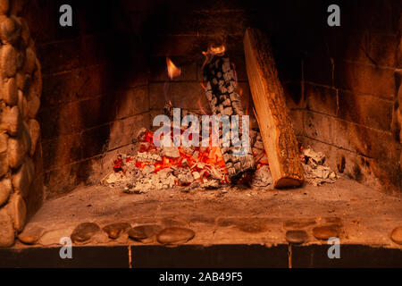 Des flammes dans la cheminée. La combustion du bois. Cheminée en brique Banque D'Images