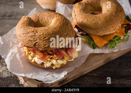 Sandwich Bagel avec bacon, oeufs et fromage sur la table en bois. Banque D'Images